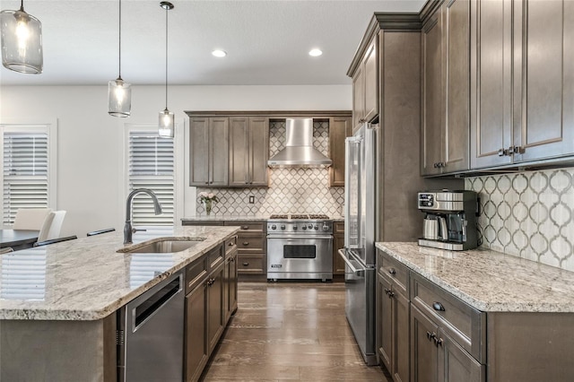 311 12th Ave N, Saint Petersburg, FL 33701 - kitchen with premium appliances, wall chimney exhaust hood, tasteful backsplash, light stone countertops, and recessed lighting