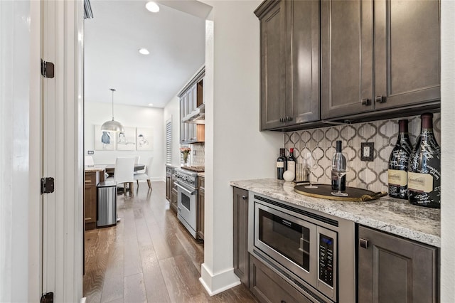 311 12th Ave N, Saint Petersburg, FL 33701 - kitchen with appliances with stainless steel finishes, dark brown cabinets, dark wood-style floors, decorative backsplash, and recessed lighting