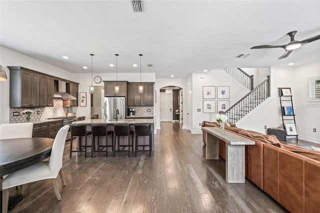 311 12th Ave N, Saint Petersburg, FL 33701 - kitchen with stainless steel fridge, open floor plan, dark brown cabinetry, arched walkways, and a ceiling fan