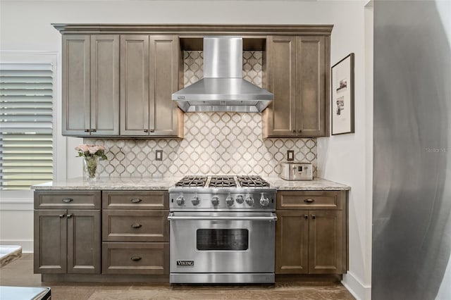311 12th Ave N, Saint Petersburg, FL 33701 - kitchen with wall chimney range hood, designer range, tasteful backsplash, and light stone countertops