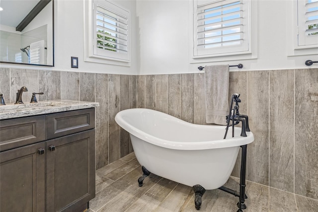311 12th Ave N, Saint Petersburg, FL 33701 - full bathroom featuring a soaking tub, tile walls, vanity, and a wainscoted wall