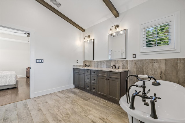 311 12th Ave N, Saint Petersburg, FL 33701 - ensuite bathroom featuring double vanity, a tub, wainscoting, and wood finished floors