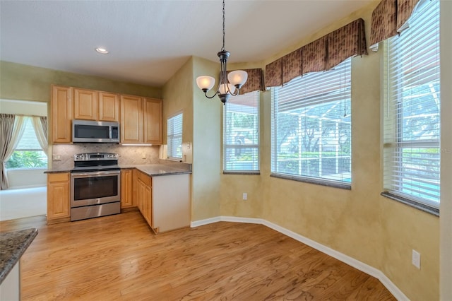 5315 Cedarshake Ln, Valrico, FL 33596 - kitchen featuring appliances with stainless steel finishes, a chandelier, light brown cabinetry, and dark countertops