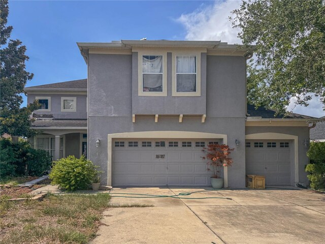 16027 Vine Cliff Ave, Hudson, FL 34667 - view of front of property featuring concrete driveway, stucco siding, and a garage