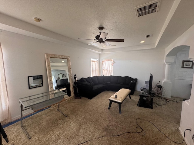 16027 Vine Cliff Ave, Hudson, FL 34667 - living room with ceiling fan, carpet, a textured ceiling, a raised ceiling, and arched walkways