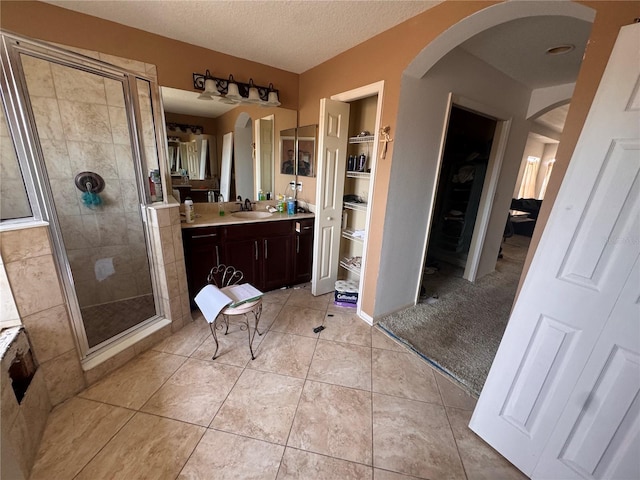 16027 Vine Cliff Ave, Hudson, FL 34667 - full bathroom with a stall shower, vanity, tile patterned flooring, a walk in closet, and a textured ceiling