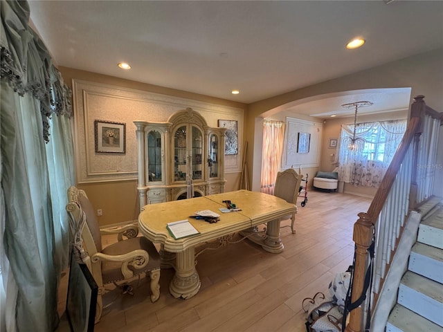 16027 Vine Cliff Ave, Hudson, FL 34667 - dining space featuring arched walkways, light wood finished floors, recessed lighting, stairway, and a chandelier
