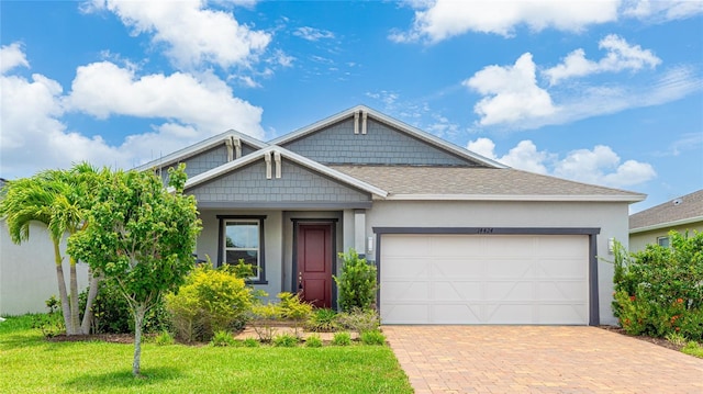 14424 59th Cir E, Bradenton, FL 34211 - view of front of house featuring decorative driveway, a front lawn, stucco siding, an attached garage, and roof with shingles