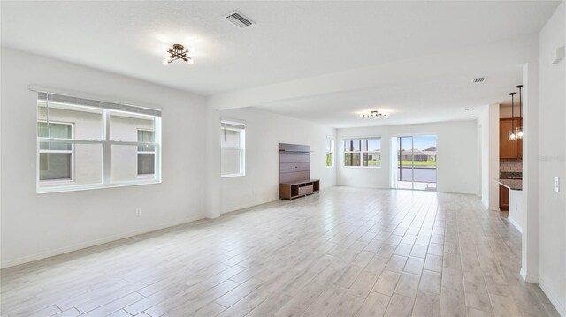 14424 59th Cir E, Bradenton, FL 34211 - unfurnished living room featuring light wood-type flooring and a chandelier