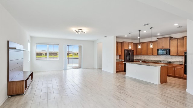 14424 59th Cir E, Bradenton, FL 34211 - kitchen featuring black appliances, open floor plan, brown cabinets, tasteful backsplash, and dark stone countertops