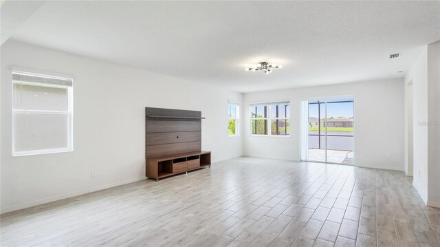 14424 59th Cir E, Bradenton, FL 34211 - unfurnished living room featuring light wood-type flooring and baseboards
