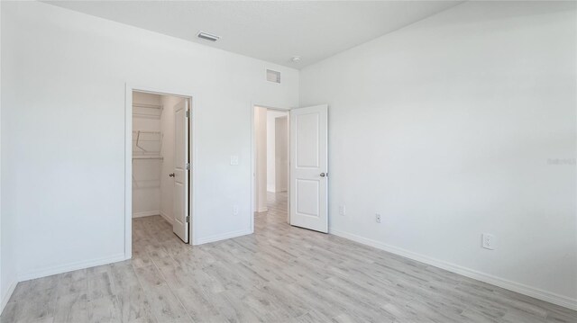 14424 59th Cir E, Bradenton, FL 34211 - unfurnished bedroom featuring a walk in closet, light wood-type flooring, and a closet