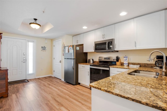 12000 Gulf Blvd Unit 403-S, Treasure Island, FL 33706 - kitchen with stainless steel appliances, white cabinets, light wood-type flooring, light stone counters, and recessed lighting