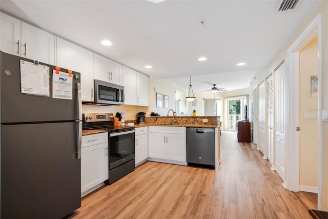12000 Gulf Blvd Unit 403-S, Treasure Island, FL 33706 - kitchen with appliances with stainless steel finishes, a peninsula, white cabinets, light wood finished floors, and recessed lighting