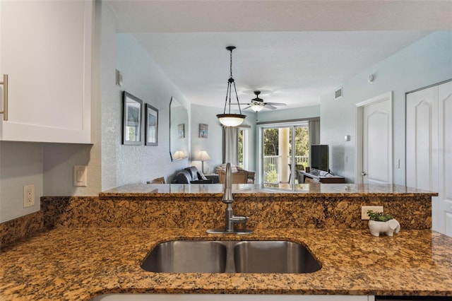 12000 Gulf Blvd Unit 403-S, Treasure Island, FL 33706 - kitchen with open floor plan, ceiling fan, dark stone countertops, white cabinets, and decorative light fixtures