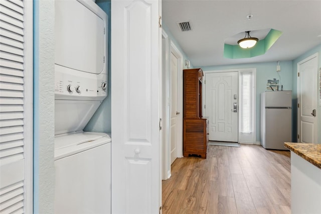12000 Gulf Blvd Unit 403-S, Treasure Island, FL 33706 - laundry area with stacked washer and clothes dryer and light wood-type flooring