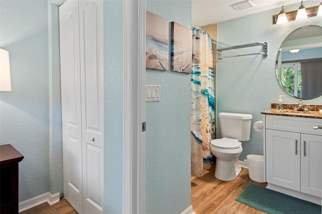 12000 Gulf Blvd Unit 403-S, Treasure Island, FL 33706 - bathroom with wood finished floors, vanity, a textured wall, a closet, and curtained shower