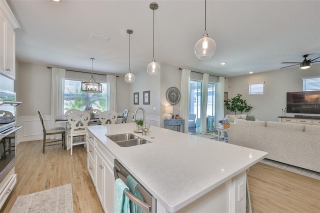 314 Blackrock Ln, Apollo Beach, FL 33572 - kitchen featuring open floor plan, light wood-style floors, white cabinets, an island with sink, and recessed lighting