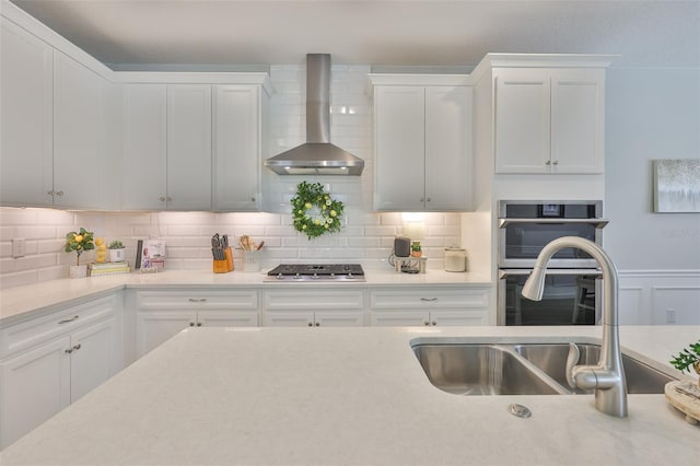 314 Blackrock Ln, Apollo Beach, FL 33572 - kitchen featuring wall chimney range hood, light countertops, decorative backsplash, and white cabinets