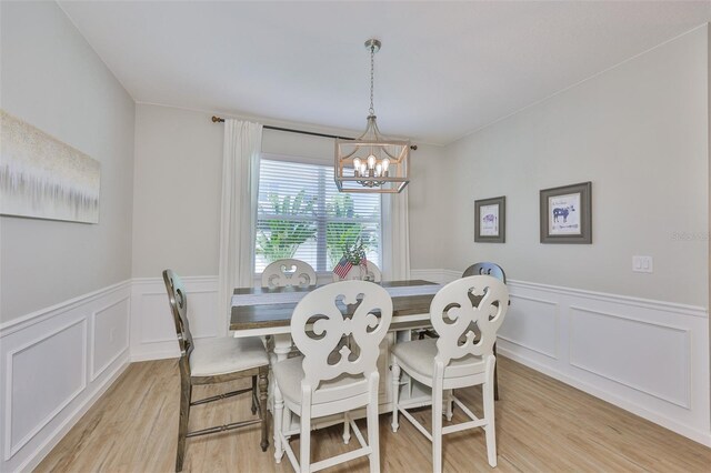 314 Blackrock Ln, Apollo Beach, FL 33572 - dining room featuring light wood-style floors, a chandelier, a decorative wall, and wainscoting