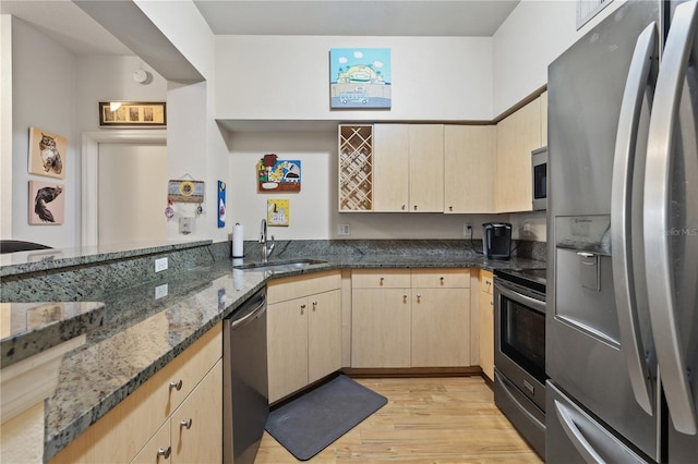 100 4th Ave S Unit 103, Saint Petersburg, FL 33701 - kitchen with stainless steel appliances, light brown cabinets, light wood-style floors, dark stone countertops, and a peninsula