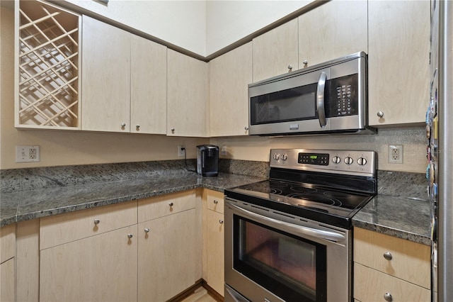 100 4th Ave S Unit 103, Saint Petersburg, FL 33701 - kitchen featuring appliances with stainless steel finishes, light brown cabinetry, and dark stone countertops