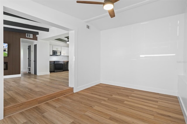 1707 Windsor Way, Tampa, FL 33619 - unfurnished room with a ceiling fan, beam ceiling, and light wood-style floors