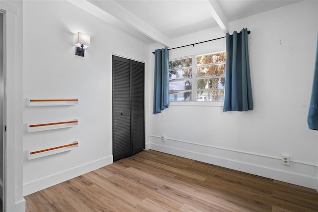 1707 Windsor Way, Tampa, FL 33619 - unfurnished bedroom with wood finished floors, a closet, and beamed ceiling