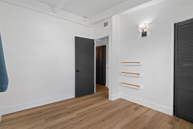 1707 Windsor Way, Tampa, FL 33619 - spare room featuring light wood-style floors and beam ceiling