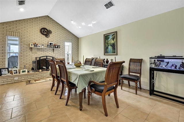 13814 Lavender Ave, Hudson, FL 34667 - dining room featuring brick wall, lofted ceiling, light tile patterned floors, and a brick fireplace