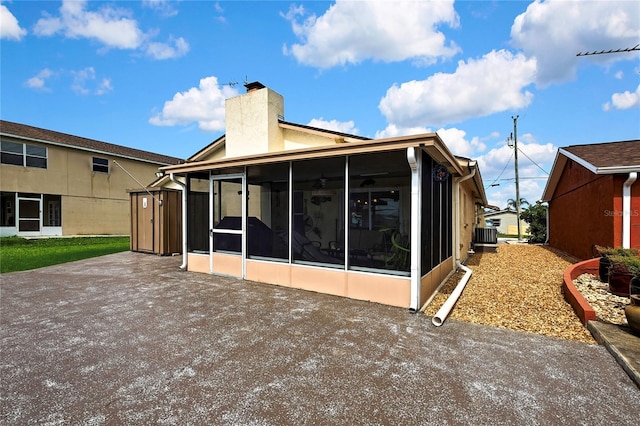 13814 Lavender Ave, Hudson, FL 34667 - back of property with a sunroom, a chimney, and a patio