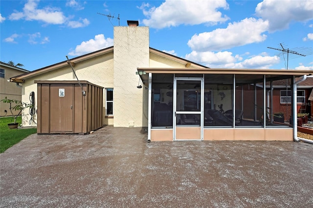 13814 Lavender Ave, Hudson, FL 34667 - back of house with a sunroom, a storage unit, stucco siding, and a chimney