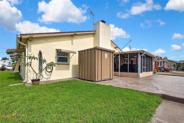 13814 Lavender Ave, Hudson, FL 34667 - rear view of house featuring a sunroom, a yard, stucco siding, and a chimney