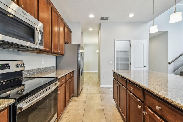 11541 Tangle Branch Ln, Gibsonton, FL 33534 - kitchen featuring appliances with stainless steel finishes, hanging light fixtures, light tile patterned flooring, light stone counters, and recessed lighting