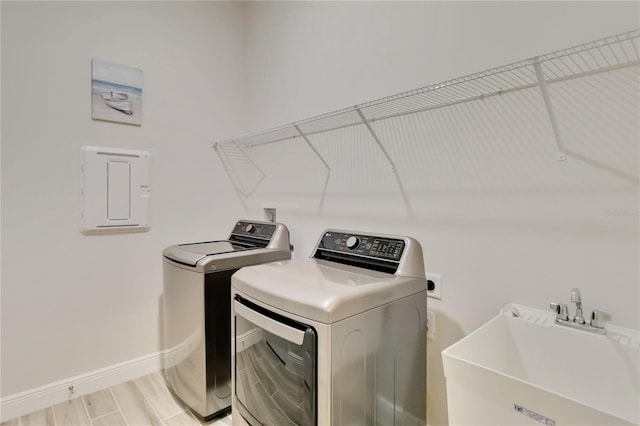 2132 Limestone Trl, Kissimmee, FL 34747 - laundry room with washing machine and clothes dryer, electric panel, and light wood-type flooring