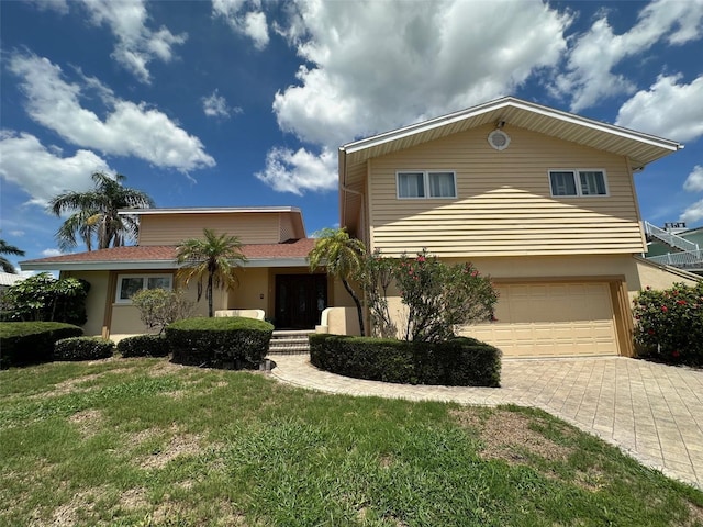 413 Midway Is, Clearwater Beach, FL 33767 - view of front of house with driveway, a garage, a front lawn, and stucco siding