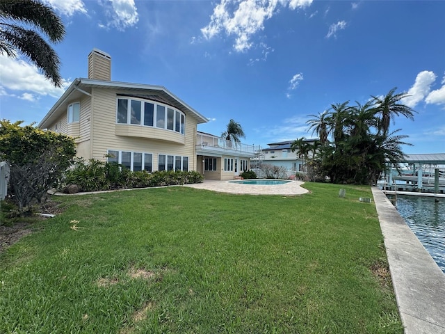 413 Midway Is, Clearwater Beach, FL 33767 - rear view of property featuring a chimney, a yard, a balcony, an outdoor pool, and a patio area