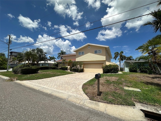 413 Midway Is, Clearwater Beach, FL 33767 - traditional-style house with a garage, decorative driveway, a front lawn, and stucco siding