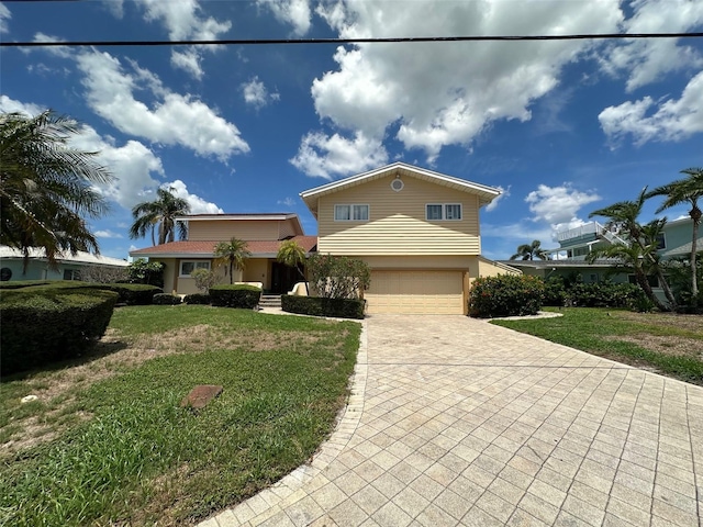 413 Midway Is, Clearwater Beach, FL 33767 - traditional-style home featuring a garage, a front lawn, driveway, and stucco siding