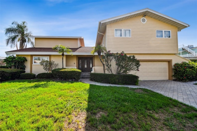 413 Midway Is, Clearwater Beach, FL 33767 - view of front of home featuring french doors, stucco siding, a front lawn, and an attached garage