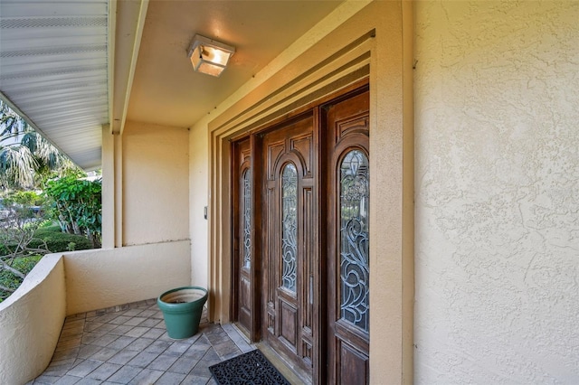 413 Midway Is, Clearwater Beach, FL 33767 - view of exterior entry featuring stucco siding and a balcony