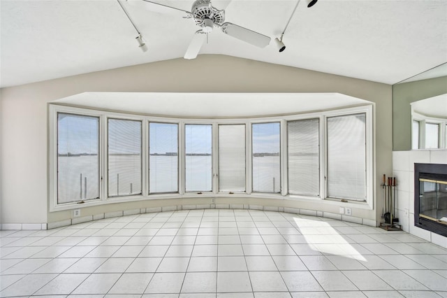 413 Midway Is, Clearwater Beach, FL 33767 - unfurnished living room with lofted ceiling, rail lighting, a tiled fireplace, light tile patterned floors, and a ceiling fan