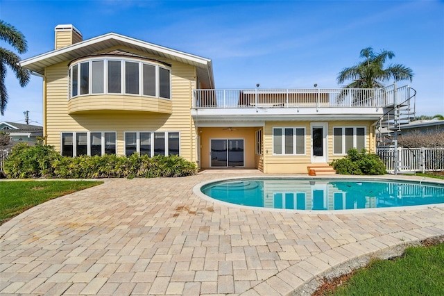 413 Midway Is, Clearwater Beach, FL 33767 - back of property with a balcony, a chimney, a patio, an outdoor pool, and entry steps
