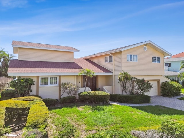 413 Midway Is, Clearwater Beach, FL 33767 - view of front of home featuring a garage, driveway, stucco siding, and a front lawn
