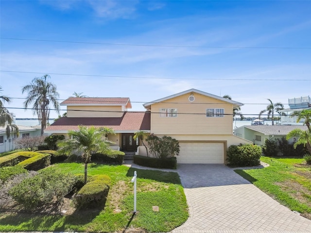 413 Midway Is, Clearwater Beach, FL 33767 - view of front of home featuring decorative driveway, an attached garage, and stucco siding