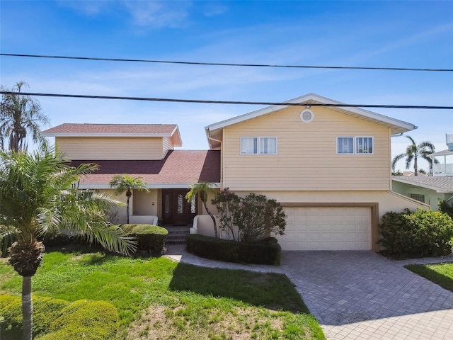 413 Midway Is, Clearwater Beach, FL 33767 - view of front of home with a garage, driveway, and stucco siding