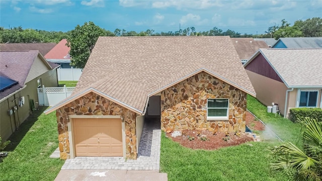 1331 Coolmont Dr, Brandon, FL 33511 - view of front of home featuring stone siding, driveway, an attached garage, and a shingled roof