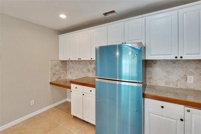 1331 Coolmont Dr, Brandon, FL 33511 - kitchen with freestanding refrigerator, tasteful backsplash, white cabinets, recessed lighting, and tile countertops