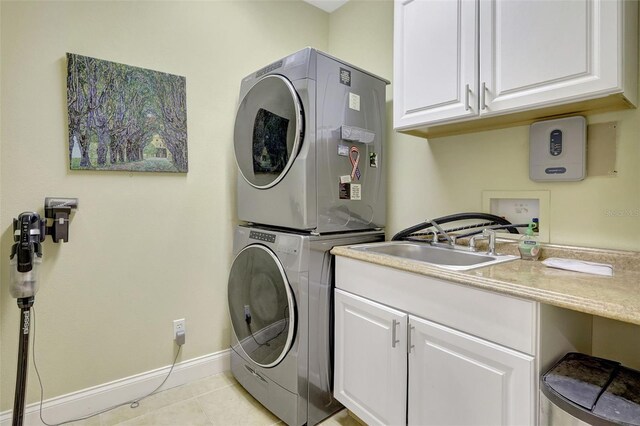 5518 Luminar Pointe Ln, Apollo Beach, FL 33572 - laundry area with stacked washer / drying machine, cabinet space, and light tile patterned floors