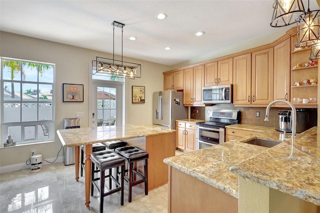 5518 Luminar Pointe Ln, Apollo Beach, FL 33572 - kitchen featuring stainless steel appliances, a chandelier, decorative backsplash, a kitchen bar, and recessed lighting
